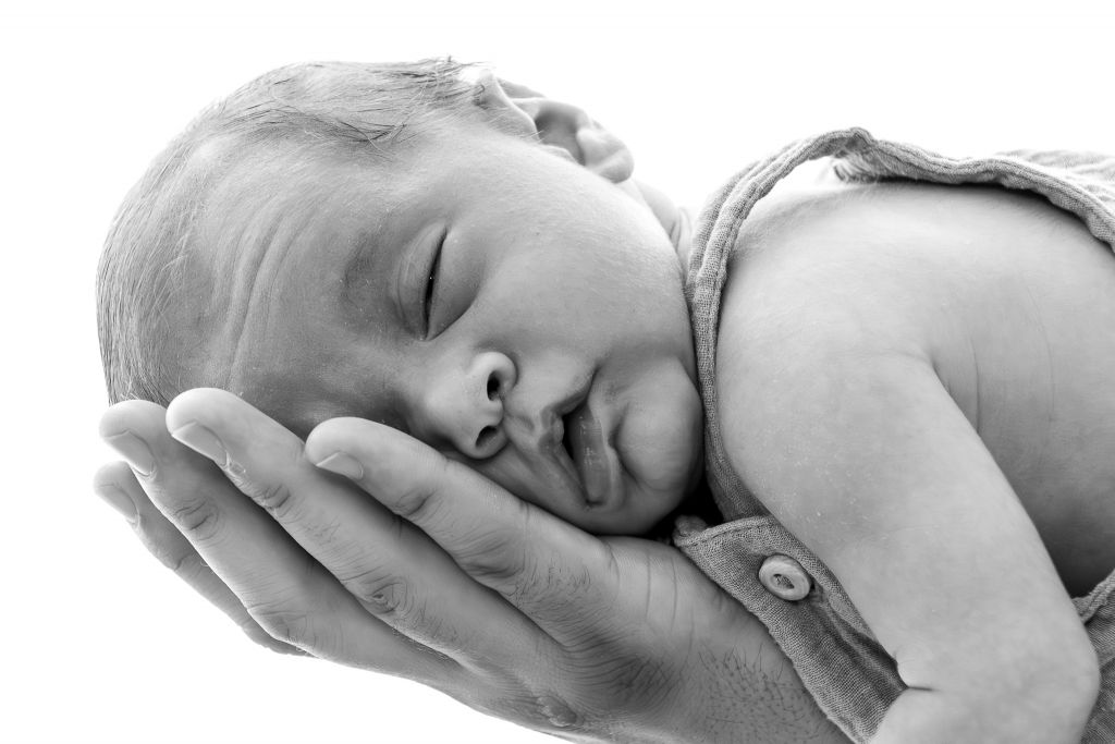 Baby auf Hand schwarz weiß Newbornfotografie