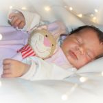 Babygirl mit Rassel und Lichterkette Newbornfotografie